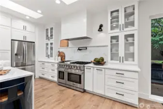 View of wall of cabinets perfect for storage and professional gas range perfect for gourmet cooking!