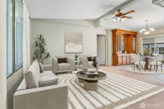 Formal living room with vaulted ceilings overlooks community greenbelt, opens to dining room.  Virtually staqed photo.