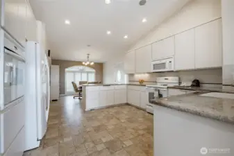 View from dining rooms side of the kitchen. See oven and wall oven. Trash compactor as well.