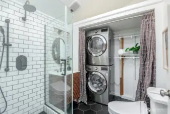 The main floor bath has beautiful tile, heated floors, and bidet. Convenient stackable washer and dryer with ample shelving for your laundry needs.