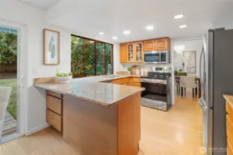 This open-concept kitchen with stone countertops, maple cabinets, and stainless steel appliances make this space both functional and stylish—with room for bar seating and did you notice the hidden cabinet tucked beneath the end of the counter? A clever touch that adds even more storage without sacrificing style.
