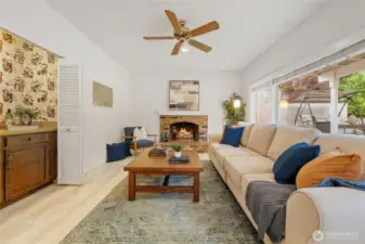 The family room features a classic brick fireplace, large windows, and a built-in wet bar—ideal for game nights, movie marathons, or easy entertaining.