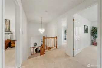 The upper level welcomes you with a view of the additional bedrooms, classic wood detailing, and a beautiful light fixture that adds a touch of charm.