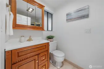 Your Primary Bath features a sleek, glass-enclosed shower, rich wood cabinetry, and a spacious mirrored medicine cabinet—all thoughtfully designed to enhance daily routines with ease and charm.