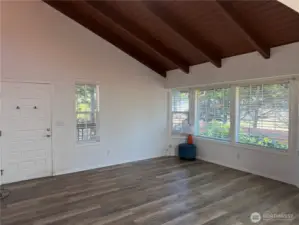 Living room with cathedral wood ceilings. Large windows for lots of light.