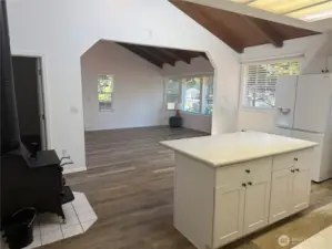 From Kitchen to living room, wood stove and island.