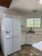 Large refrigerator. Note wood laminate flooring throughout the home except bedrooms.