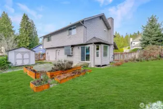 Spacious backyard with a shed is great for those with a green thumb.