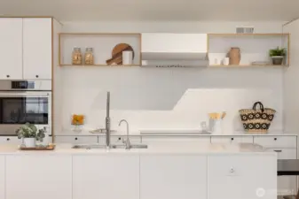 The chic modern kitchen features beautiful backsplash tile and an impressive 14-plus-foot quartz-topped island with waterfall edge