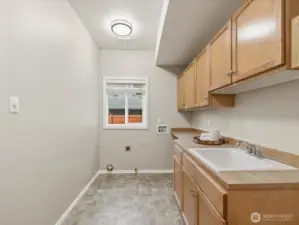 Large laundry room with lots of built-in storage and extra deep utility sink.
