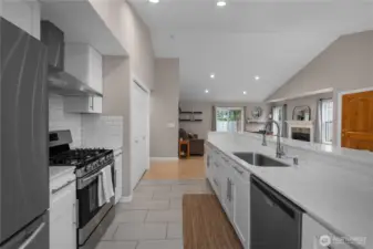 Long quartz counters, bar seating, and open sightlines create a bright, connected kitchen layout.