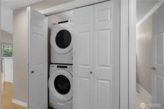 Stacked washer and dryer provide efficient laundry space without sacrificing storage or flow.