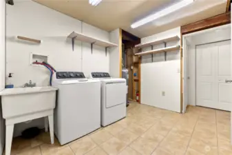 Utility room has tile floor. New appliances Washer / Dryer, Utility sink, Hot Water tank is easy access. Tons of storage shelves for supplies.