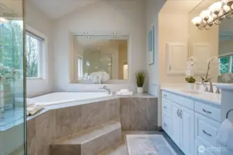 Uplifting and updated 5 piece bathroom with designer tiled floor and shower, 2-person jetted tub, make-up vanity, crisp white cabinetry with separate quartz vanities.