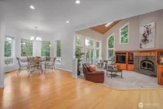 The adjacent informal dining area with walls of windows overlooks the east facing yard.