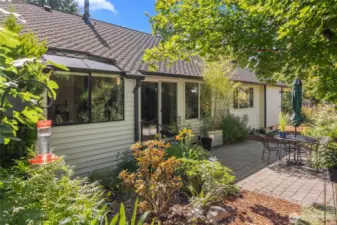 Exterior back with luscious landscaping and newer patio pavers