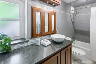 The updated and luxurious bath with cherry cabinetry, radiant heated floors and a wall mount towel warmer