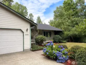 Vibrant blue hydrangeas highlight the property’s lush, mature landscaping. Making it a welcoming entry for all.