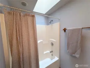 Convenient full bath off the hallway, enhanced by a skylight above.