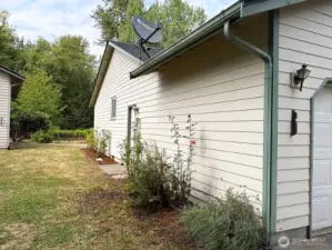 A colorful row of rose bushes adds timeless charm and fragrance along the side of the home.