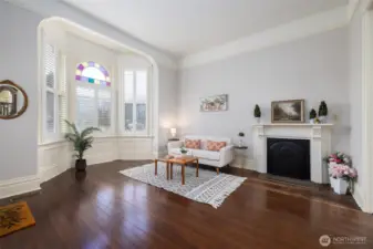 Elegant bay-window sitting room with classic fireplace.