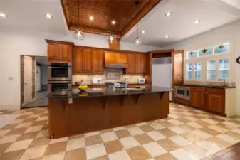 Spacious chef's kitchen with ornate tin ceiling.
