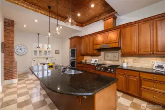 Spacious chef's kitchen with ornate tin ceiling.