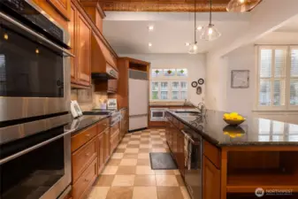 Warm, spacious kitchen with wood cabinetry, granite counters, and stained-glass accents.