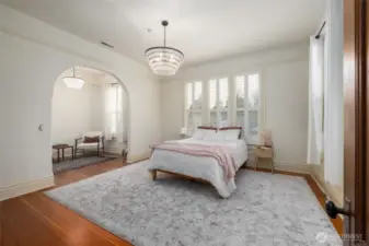 Bright primary bedroom with sitting alcove, with custom shutters.