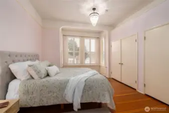 Bright bedroom with bay windows and chandelier.