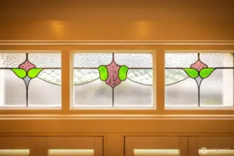 Colorful stained-glass transom windows with pink and green floral-style designs.