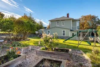 Sunny yard with raised garden beds and playset.