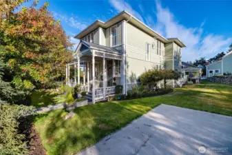 Sunny side yard with stone wall and patio chair.