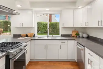 Beautifully remodeled kitchen with updated sleek countertops, cabinetry and stainless appliances.
