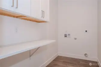 The Utility Room features ample cabinetry for storage, great counterspace for folding laundry and LVP flooring.