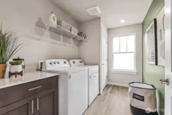 Dedicated laundry room with folding table. Photo is representational. Actual home is under construction and finishes will vary. See site agent for details.