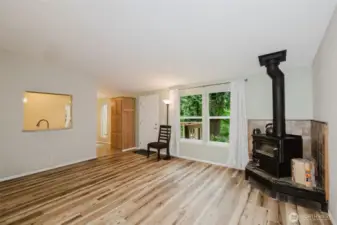 Wood stove in living room.  looking accross the living room at the front door and entrance to the kitchen.