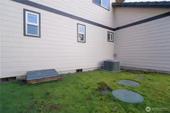 Side of home with crawl space access, AC unit, and septic lids