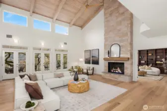 Inside, a grand living room with soaring 25-foot wood-beamed ceilings makes an unforgettable first impression.