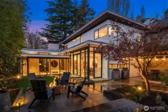 Designed by notable PNW architect Patrick William Donnelly as the personal residence for a custom home builder, this custom residence pairs a dramatic, sculptural silhouette with refined materials of lyrical restraint: warm, inviting finishes grounded in thoughtful minimalism, where every line feels intentional and every view feels curated.  The setting is as rare as the design. An adjacent greenspace and the 230-acre Washington Park Arboretum is quite literally your front yard, and the arrival feels inspired—as if you’re walking home from the park. And the neighborhood itself is part of the magic. This is one of Seattle’s rare pockets where you get genuine privacy and calm without losing proximity—an established, primarily residential enclave with a legacy-home feel, tucked between water, parkland, and the University. It lives differently than denser, more commercial Seattle neighborhoods: more canopy, more quiet, more space to exhale—yet still remarkably connected.