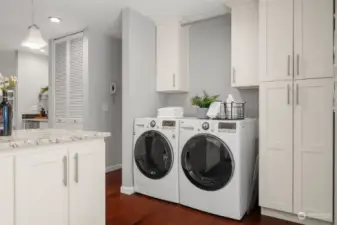 The laundry facility is located off the kitchen, surrounded by beautiful matching kitchen cabinetry for added storage.
