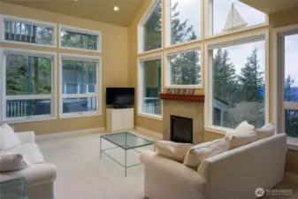 Greeted with light filled living room surrounded by windows. Trees, water, mountains!