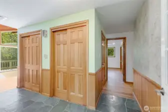 Main entrance to home has original slate floors and large coat closets.