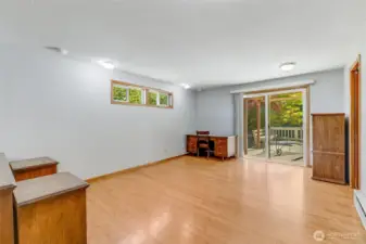 Primary bedroom has LVP flooring and leads out to back patio through slider