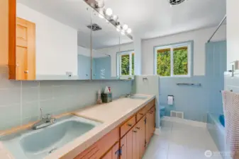 Main bathroom has double sinks, original tiles with updated tile floors