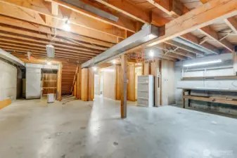 Unfinished portion of downstairs is spacious with built in work bench
