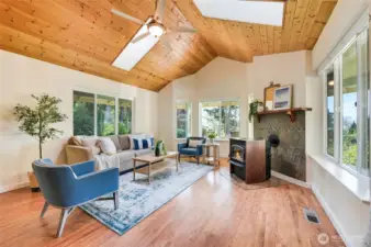 Living room with cozy pellet stove, views, and plenty of natural light