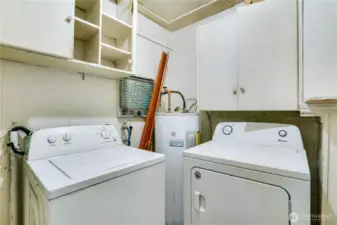 Utility room includes washer, dryer, and storage cabinets—functional space to build on.