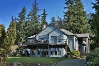 Located at the end of the lane, this is the view driving up to your home. The newer composite deck expands the entire length of the view side of your home. Exterior stairs lead from the deck to your yard.