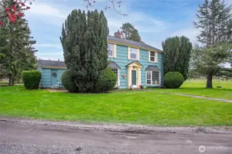 The driveway wraps around this side of the house. Notice the small patio on the left, this is located just off the kitchen and the door you see leads to the mud/utility room.